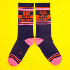 Another flat lay showcasing the 'Big City Energy' socks, this time laid out in a more spread-out manner on a yellow background. [lf]