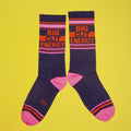 Lifestyle shot showing one 'Big City Energy' sock casually arranged on a yellow background. [lf]