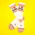 Pair of 'I Heart Beans' socks crossed on a yellow background.