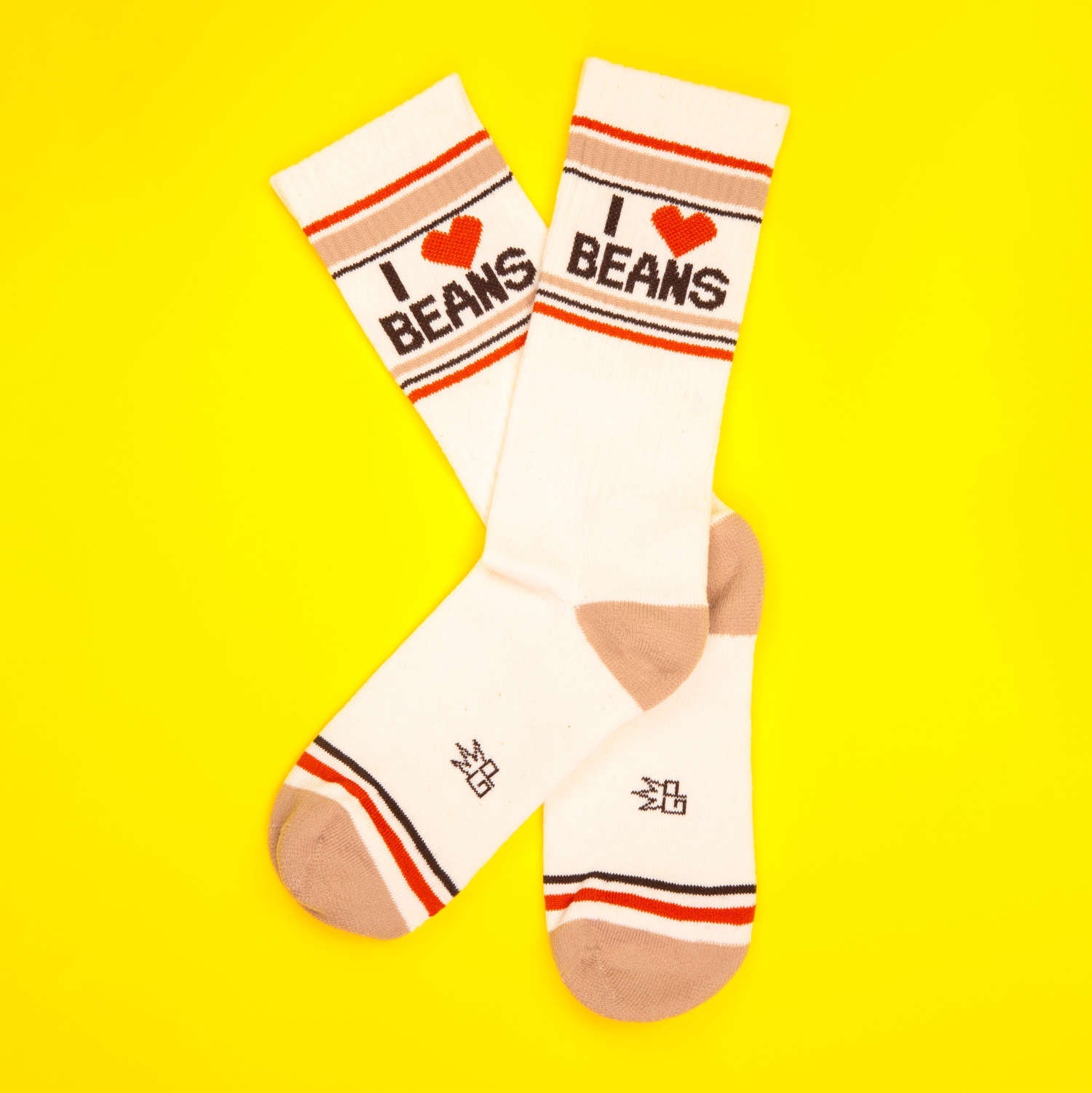 Pair of 'I Heart Beans' socks crossed on a yellow background.