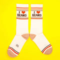 Flatlay of 'I Heart Beans' socks on a yellow background.
