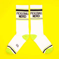 Pair of Pickleball Nerd socks displayed flat on a yellow background. [lf]