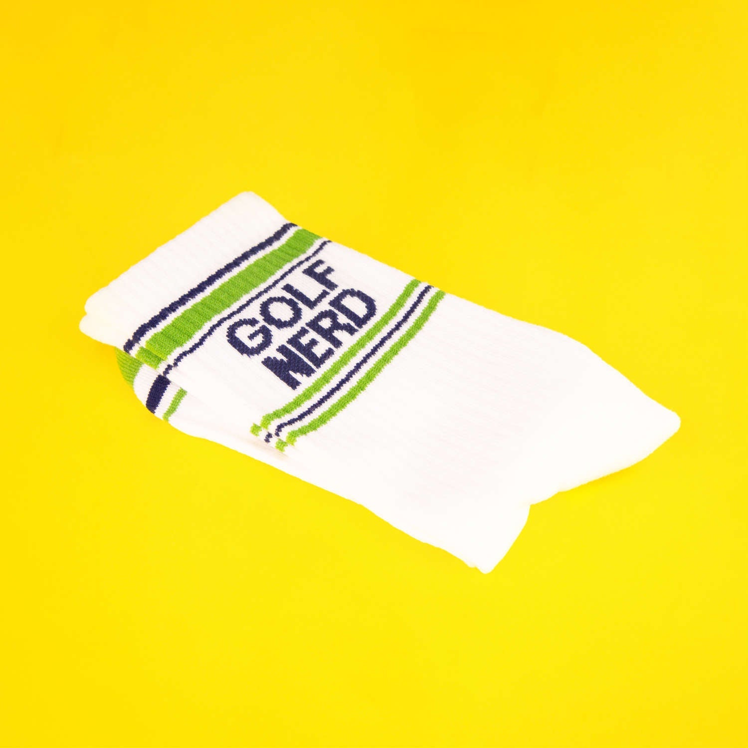 Close-up of Golf Nerd socks folded on a yellow background. [lf]