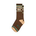 Pair of brown crew socks with a retro-style 'COFFEE NERD' graphic in cream and teal.  Features a peach-colored cuff.