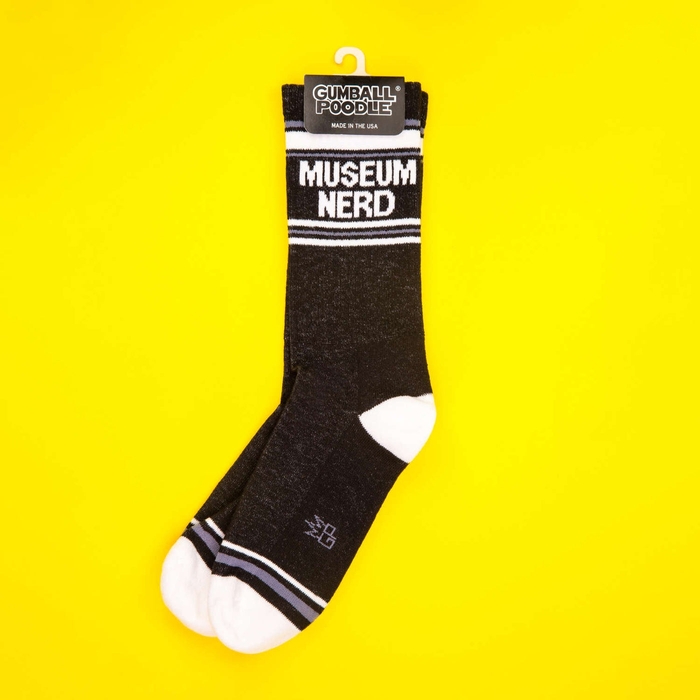 Museum Nerd socks on a yellow background; folded. [lf]
