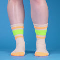 Lifestyle shot: A pair of Bobby socks, folded, on a dark brown background. [lf]