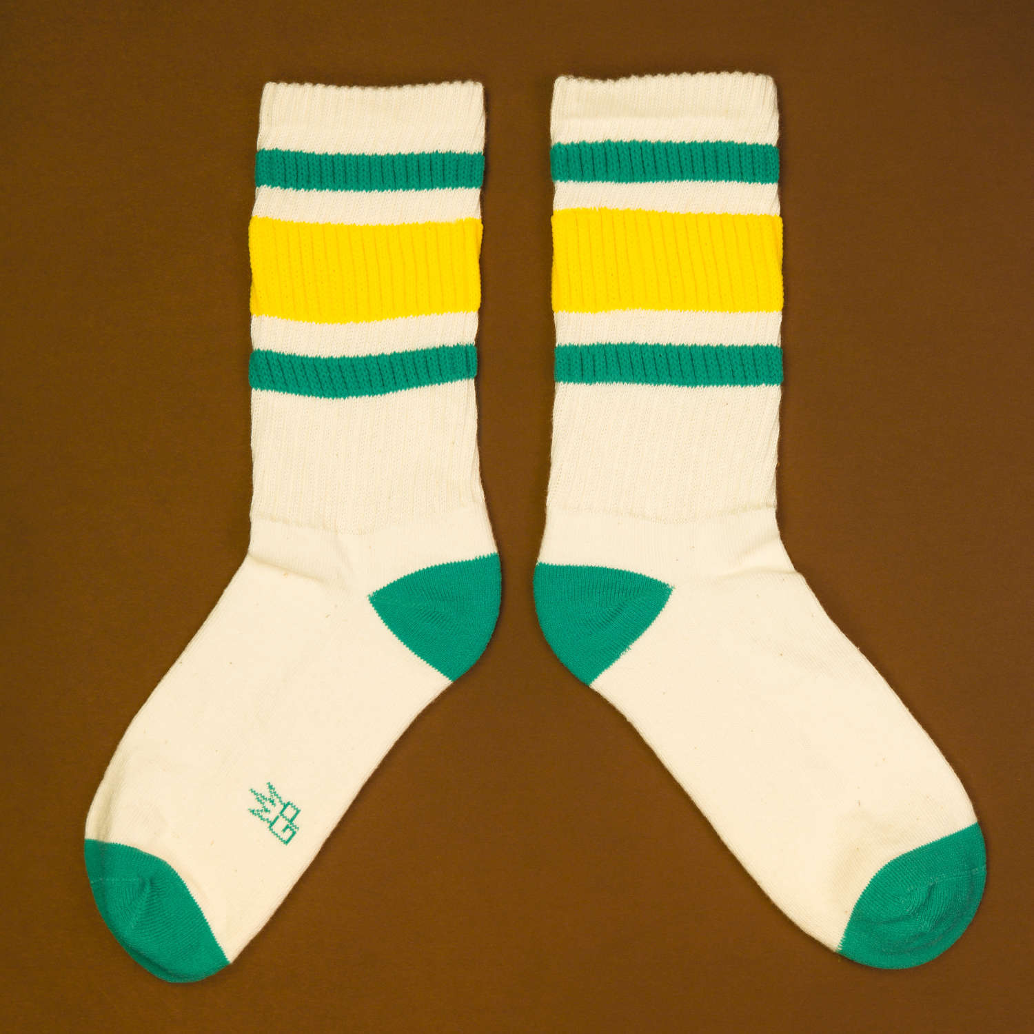 Another flat lay of Carol socks, slightly offset, on a brown background. [lf]