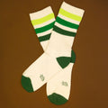 Flat lay product shot of Greg socks on a brown background, highlighting the color and design. [lf]