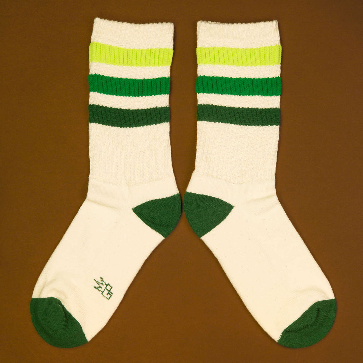 Flat lay product shot of Greg socks on a brown background, showing the socks laid out. [lf]