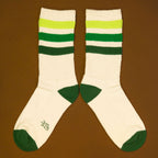 Flat lay product shot of Greg socks on a brown background, showing the socks laid out. [lf]