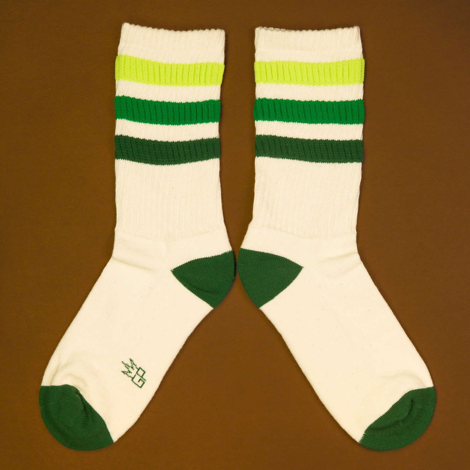 Flat lay product shot of Greg socks on a brown background, showing the socks laid out. [lf]