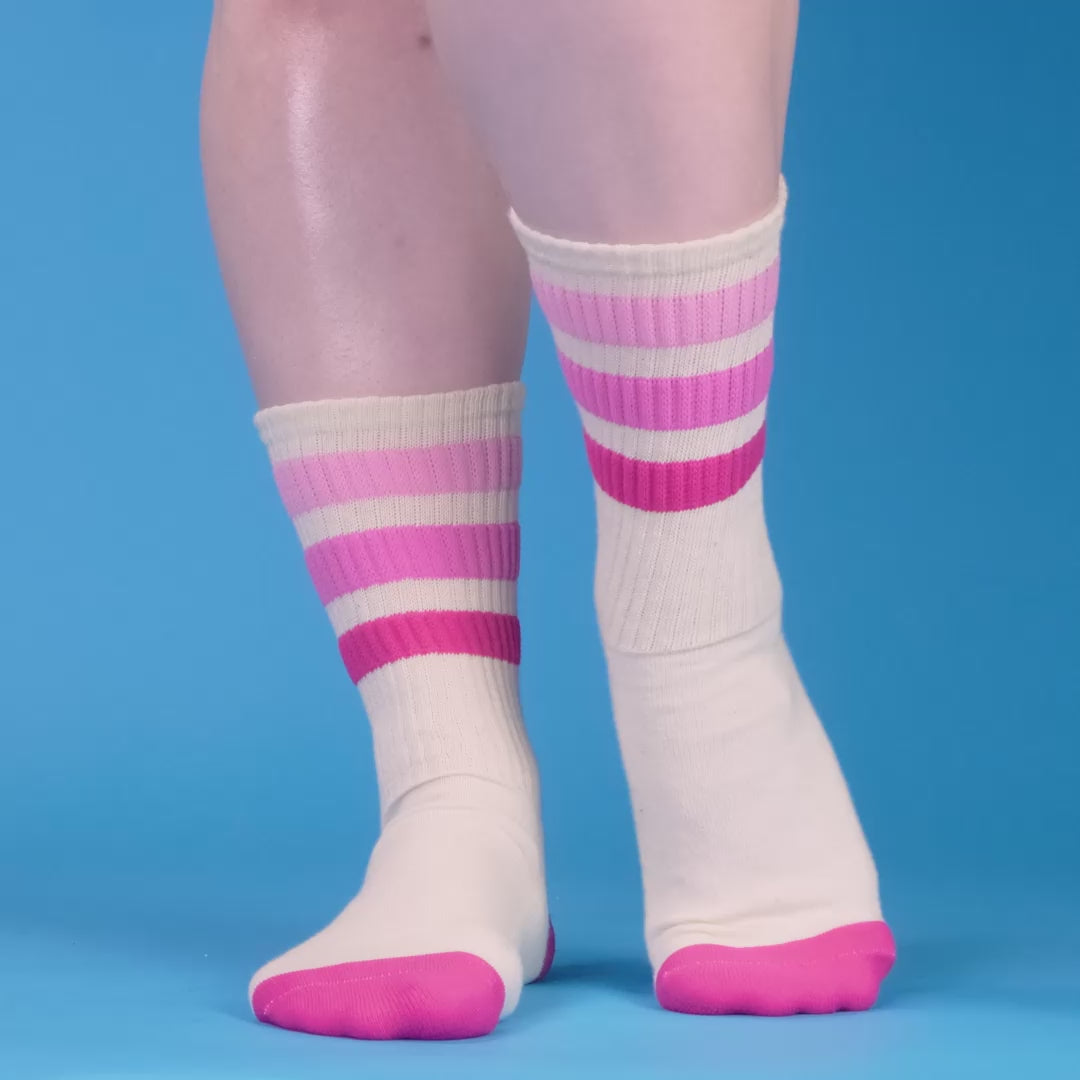 Close-up of folded cream crew socks with pink and red stripes. [lf]