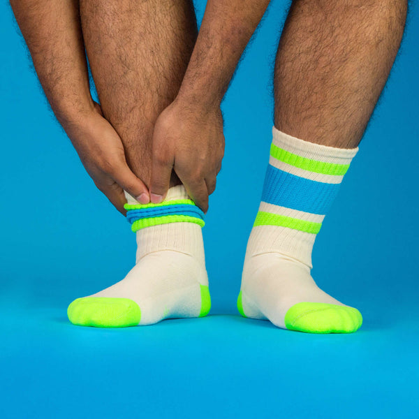 Lifestyle shot of a person's legs wearing the Peter socks against a blue background. [lf]