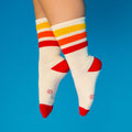 Lifestyle shot: Tiger socks on feet against a bright blue background. [lf]