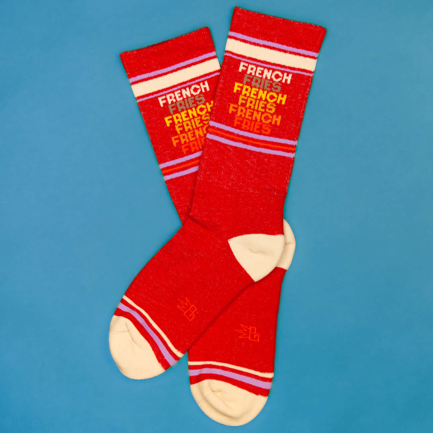 Flatlay image of two 'French Fries' socks on a blue background. [lf]