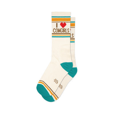 front view of a pair of white crew socks with teal, brown, and yellow stripes and the words "i love cowgirls" in brown with a red heart.