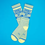 A flatlay of two 'Easily Distracted By Birds' socks on a bright blue background. [lf]