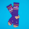Flatlay of purple 'I Heart Horses' socks on a bright blue background.