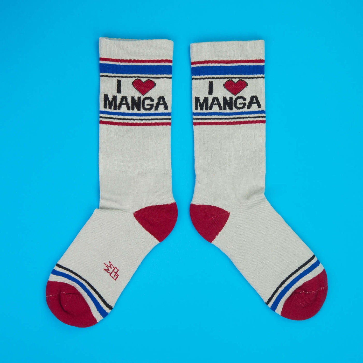 Pair of 'I Heart Manga' socks laid flat on a bright blue surface.