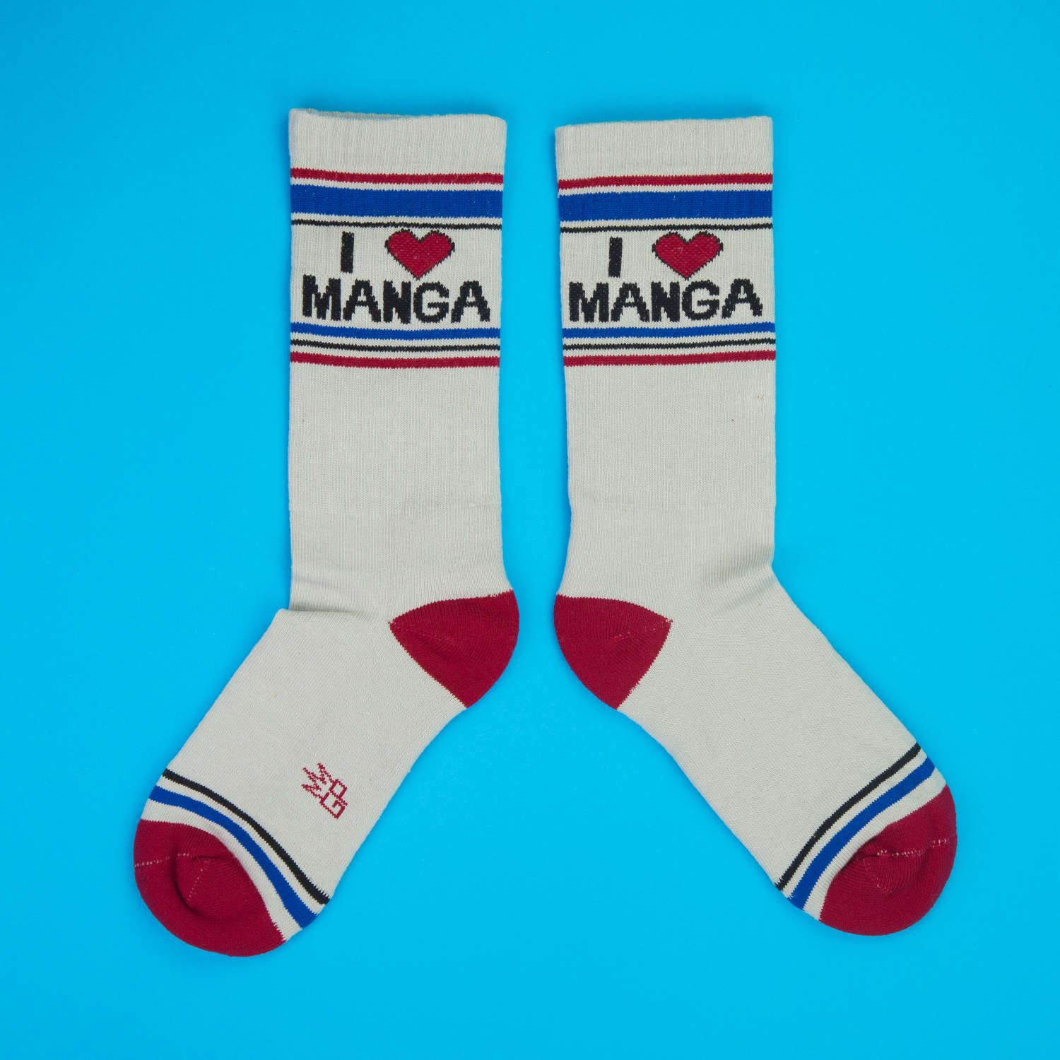 Pair of 'I Heart Manga' socks laid flat on a bright blue surface.