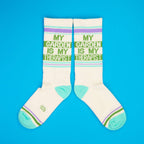 Flat lay product shot showing two 'My Garden Is My Therapist' socks on a bright blue background. [lf]