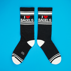 Another flatlay showcasing the 'I Heart Bagels' socks, arranged in a different position on a blue background.