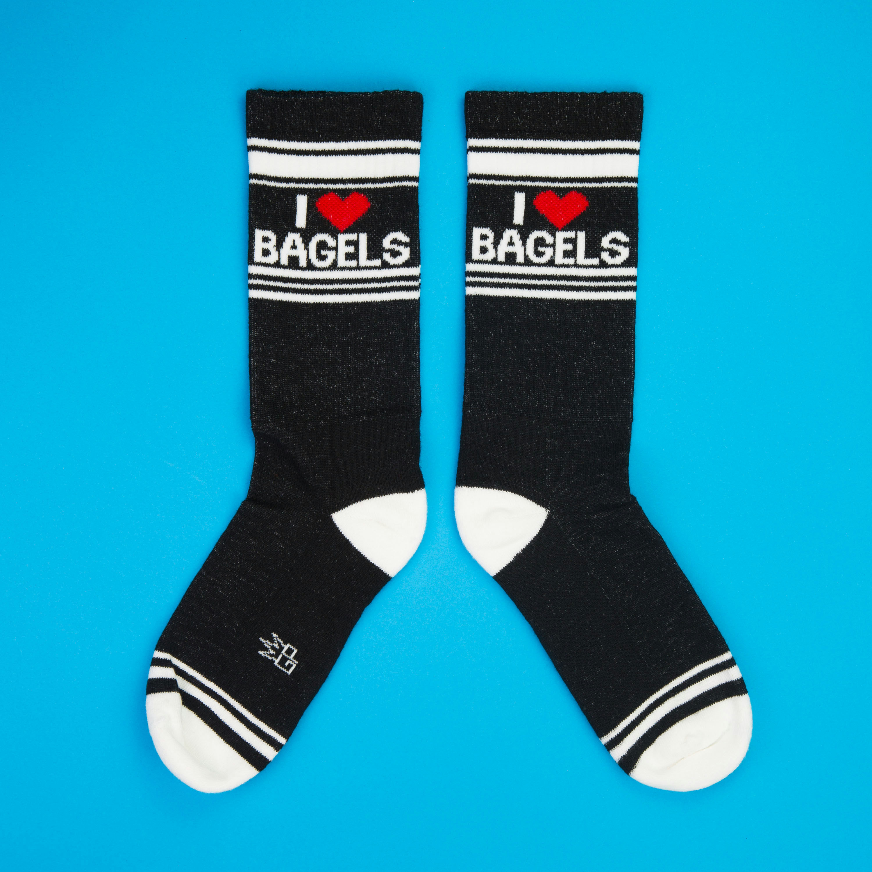 Another flatlay showcasing the 'I Heart Bagels' socks, arranged in a different position on a blue background.