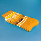 Lifestyle shot featuring feet wearing the mustard yellow 'Beer' socks. [lf]