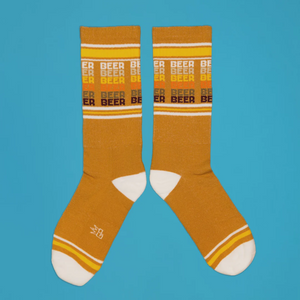 Lifestyle shot featuring feet wearing the mustard yellow 'Beer' socks.