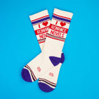 Flatlay of a pair of 'I Heart Romance Novels' socks on a blue background.