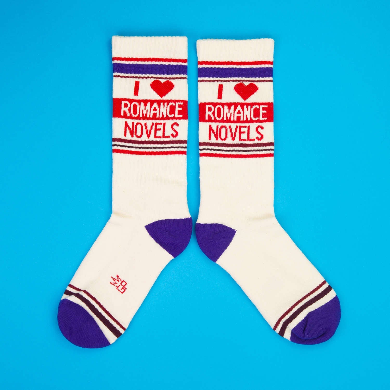 Another flatlay of 'I Heart Romance Novels' socks, on a blue background; this time, socks are laid out differently.