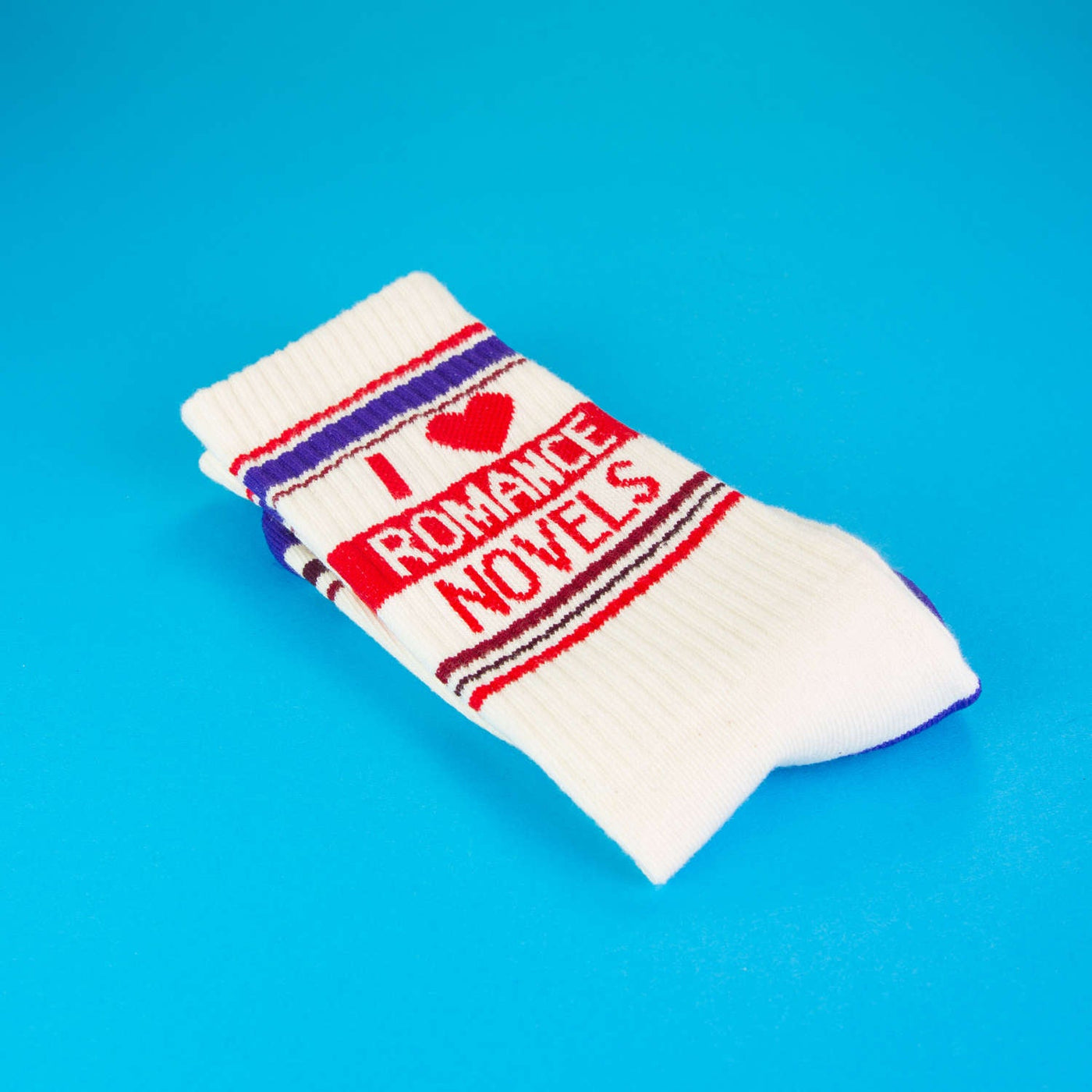 Close-up of a single 'I Heart Romance Novels' sock, folded on a blue background.