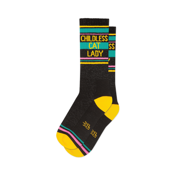 front view of two black socks with yellow, pink, and teal stripes that read 'childless cat lady'.