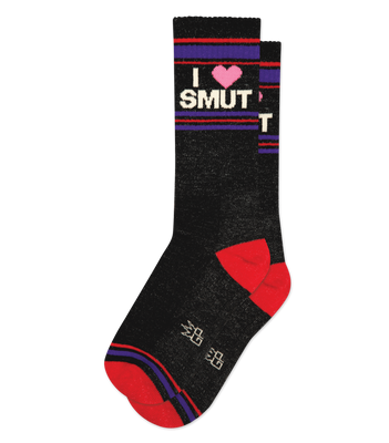 Pair of black crew socks with 'I ❤️ SMUT' text, pink heart, red toes/heels, purple stripes, and white symbols on sole.