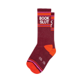 Dark red "Book Slut" crew socks featuring white text, vibrant pink & orange stripes, plus bright orange heels/toes.