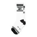 A pair of white crew socks with black stripes and the words 'Trophy Wife' in black.  The socks have a black heel and toe.
