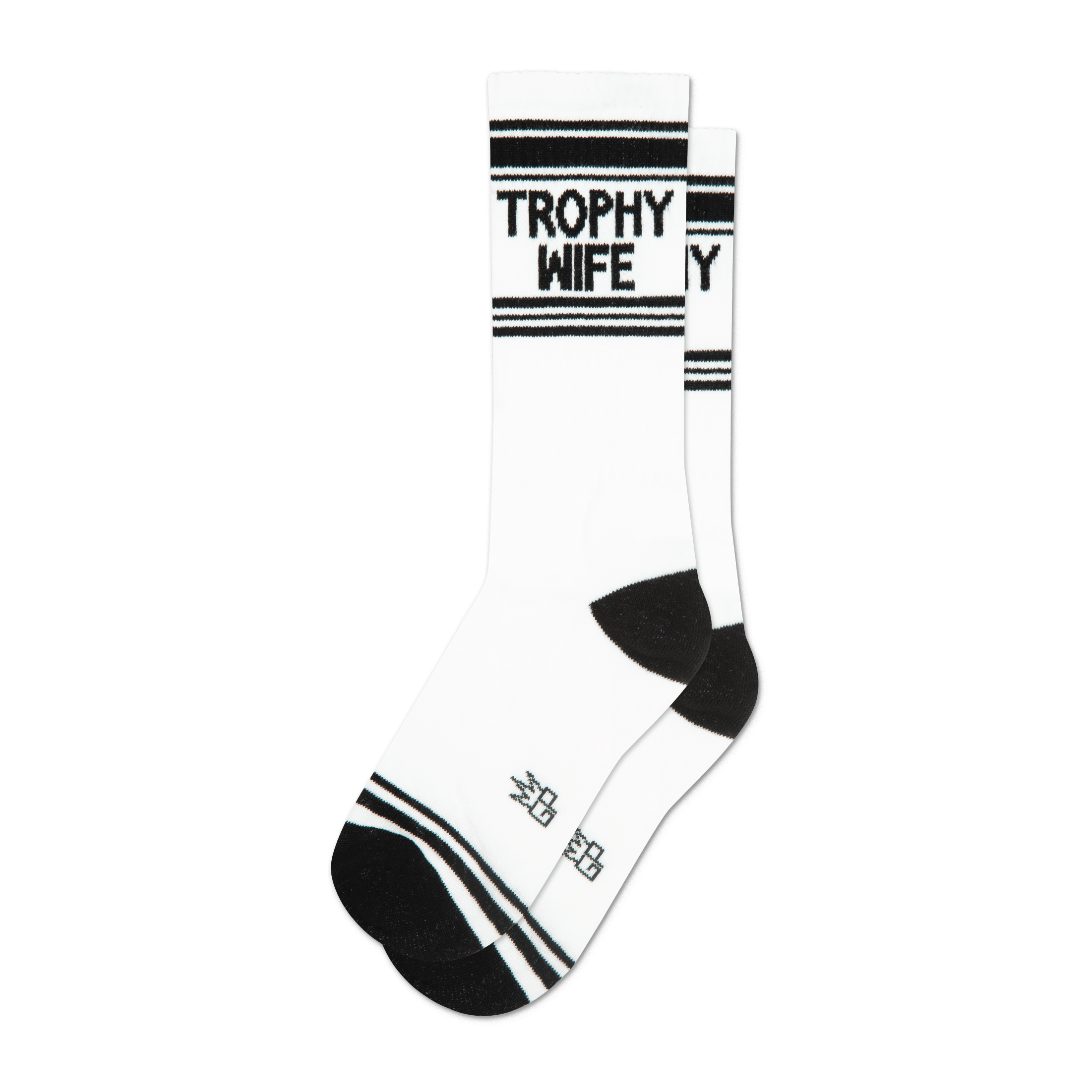 A pair of white crew socks with black stripes and the words 'Trophy Wife' in black.  The socks have a black heel and toe.