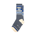 Pair of grey crew socks with blue stripes and the text 'Real Men Change Diapers'.