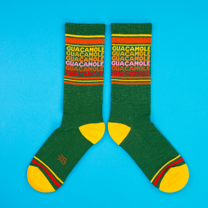 Flat lay of Guacamole socks on a bright blue background. Shows the full sock design and color.