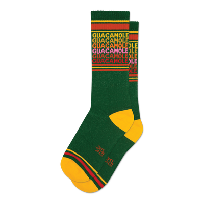 Pair of green crew socks with a repeating 'Guacamole' pattern in yellow, red, and pink. Yellow and red stripes at the top and bottom.
