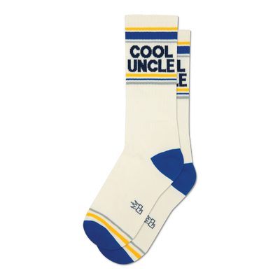 Pair of cream crew socks with "COOL UNCLE" text, blue toes and heels, and yellow and grey stripes at the cuff.