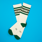 Flatlay of a pair of 'Horny' socks on a bright blue background.