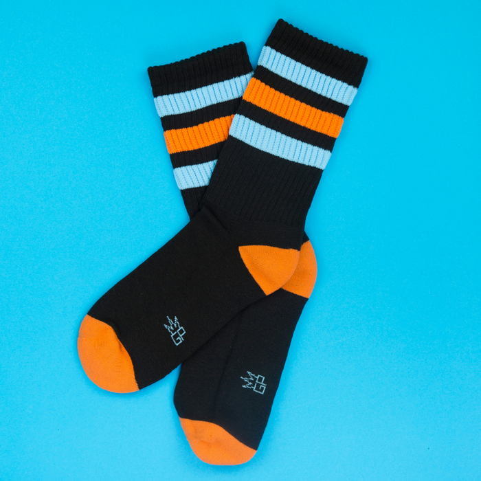 Flat lay of Astro Retro socks on a blue background. Shows the sock's design and color details.