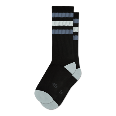 Pair of black crew socks with grey and white stripes.  Features a light grey toe and heel, and a small logo on the sole.