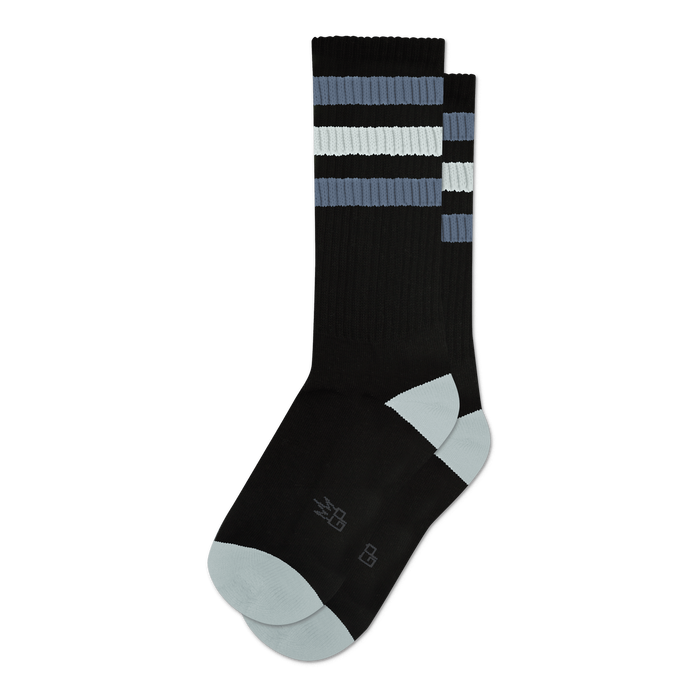 Pair of black crew socks with grey and white stripes.  Features a light grey toe and heel, and a small logo on the sole.