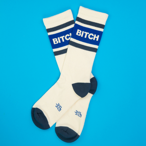 Another flatlay product shot of the 'Bitch' socks, also on a bright blue background.