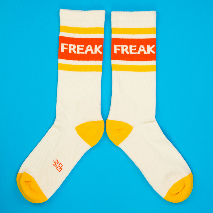 Another flat lay showcasing the 'Freak' socks, this time arranged in a spread-out position against a bright blue background.