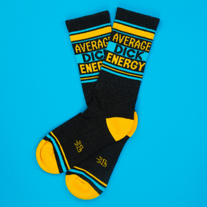 Flat lay of 'Average Dick Energy' socks on a bright blue background.