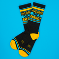 Flat lay of 'Average Dick Energy' socks on a bright blue background.