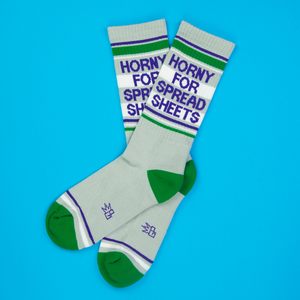 Lifestyle flatlay photo showing two 'Horny for Spreadsheets' socks on a bright blue background.